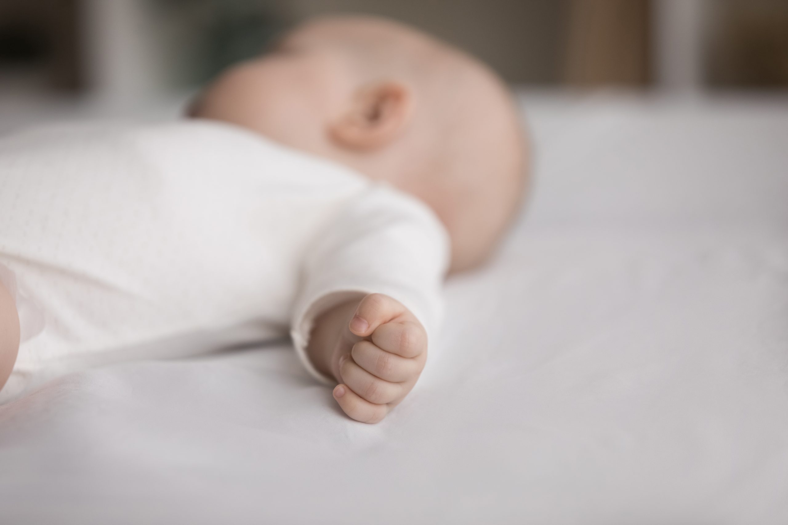 Close,Up,Of,Peaceful,Newborn,,Baby,In,Bodysuit,Falling,Asleep